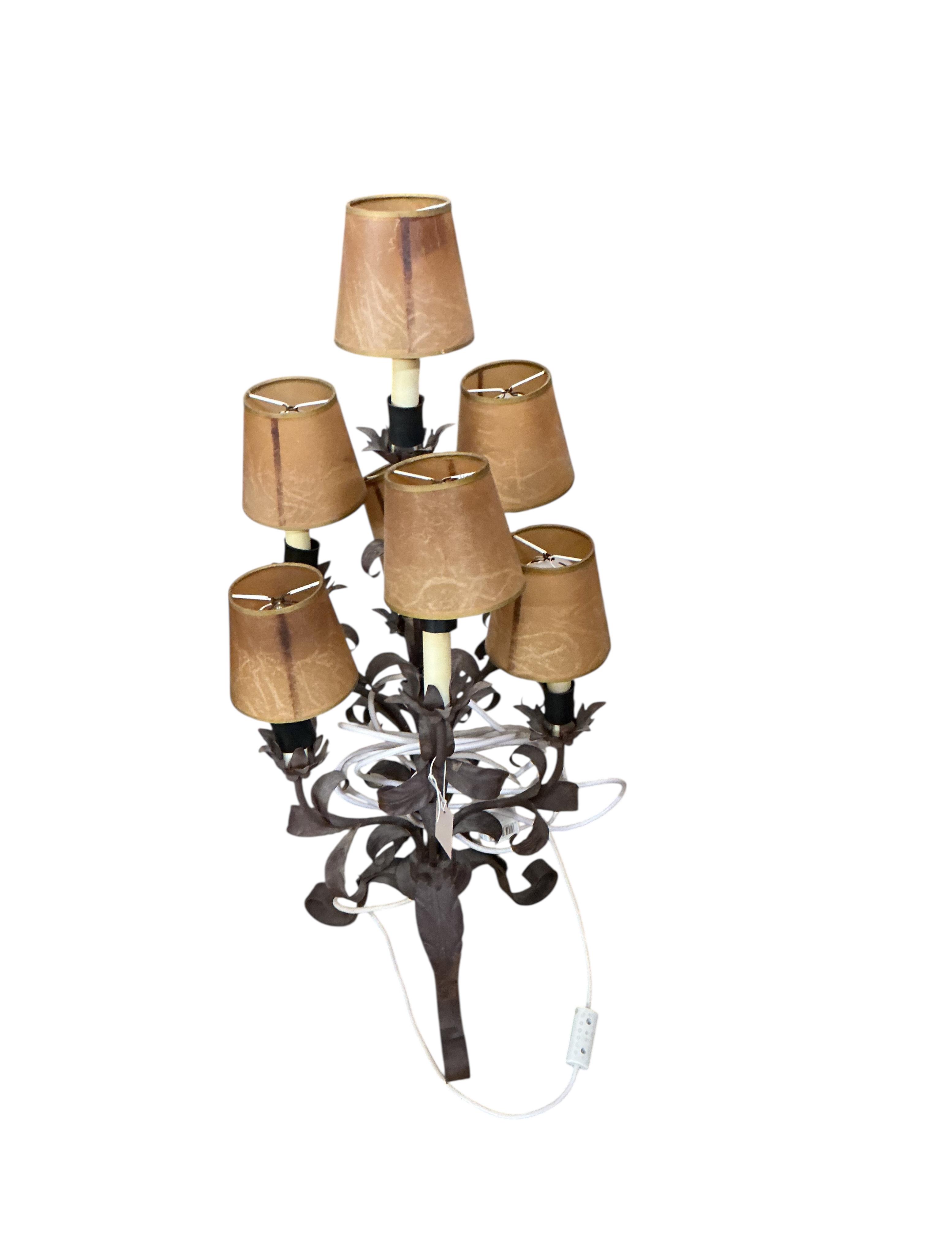 A pair of wrought and embossed four branch, five light candelabra, height 94cm